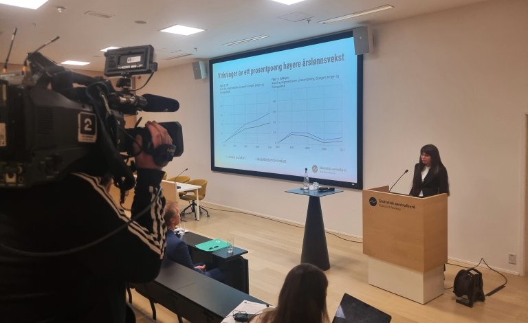 Presentasjon i auditoriet. En journalist fra TV2 står og filmer den som snakker.